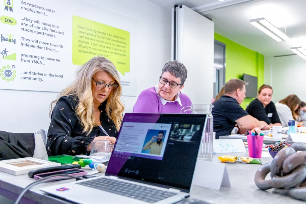 People sat working at a large desk